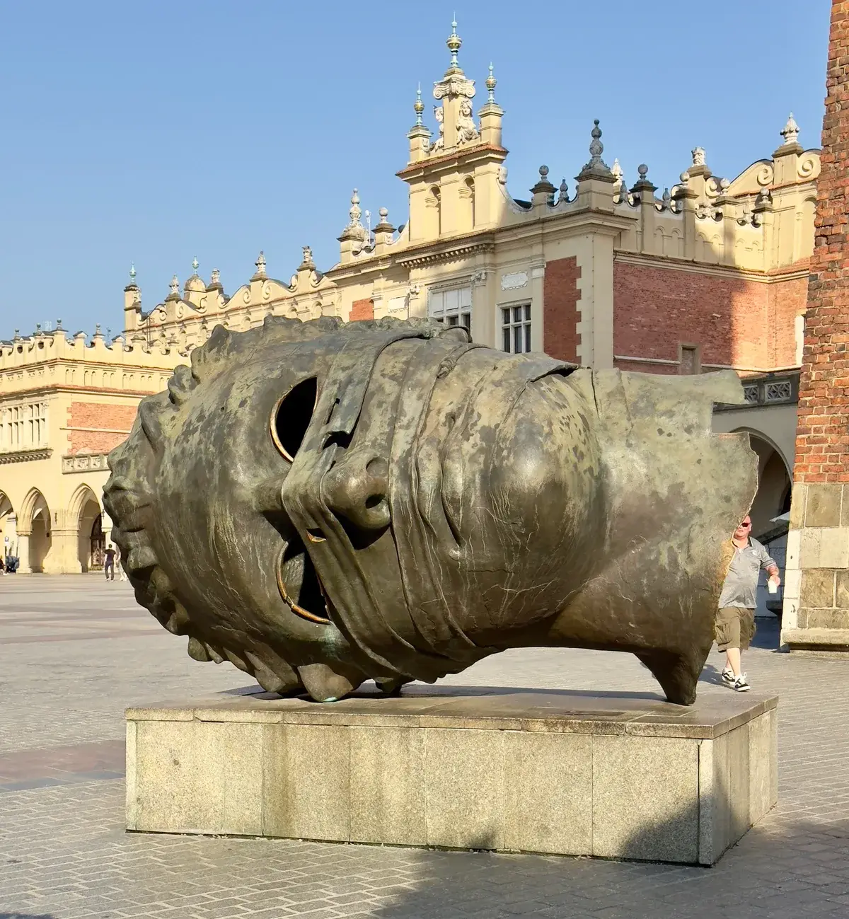 ประติมากรรมศีรษะบรอนซ์ Eros Bendato โดย Igor Mitoraj, Kraków Main Market Square — 370 × 290 ซม. 1900 กก.