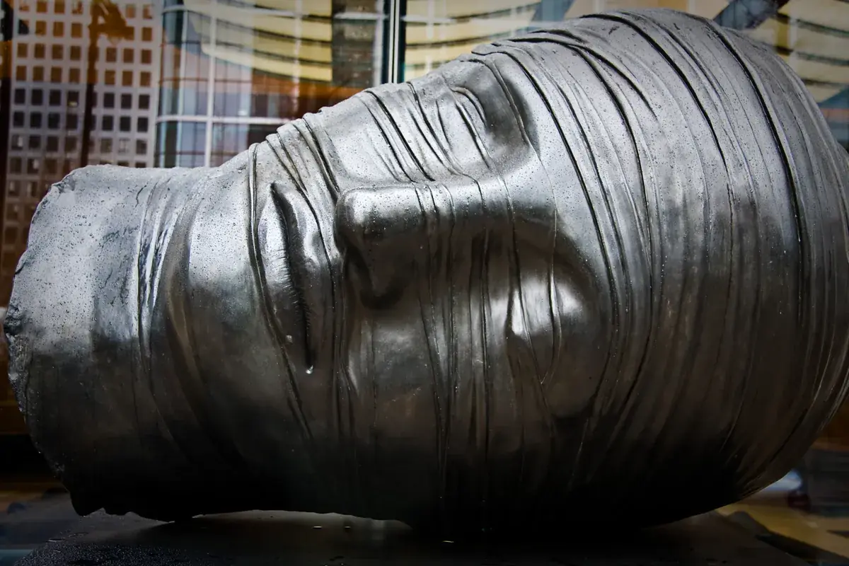 Igor Mitoraj Testa Addormentata bronze sculpture 1983, Canary Wharf, London — permanent public collection
