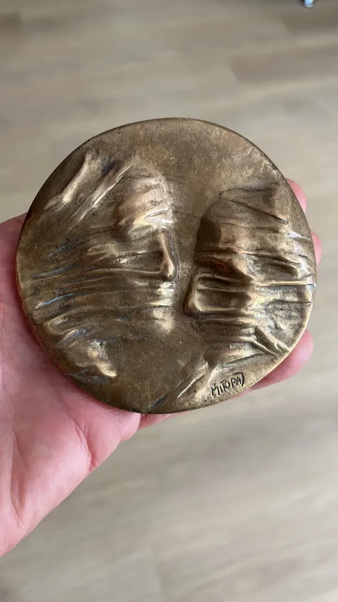 מדליית עיגול מיתוראי — פנים עם צעיף מקופל וחתימה