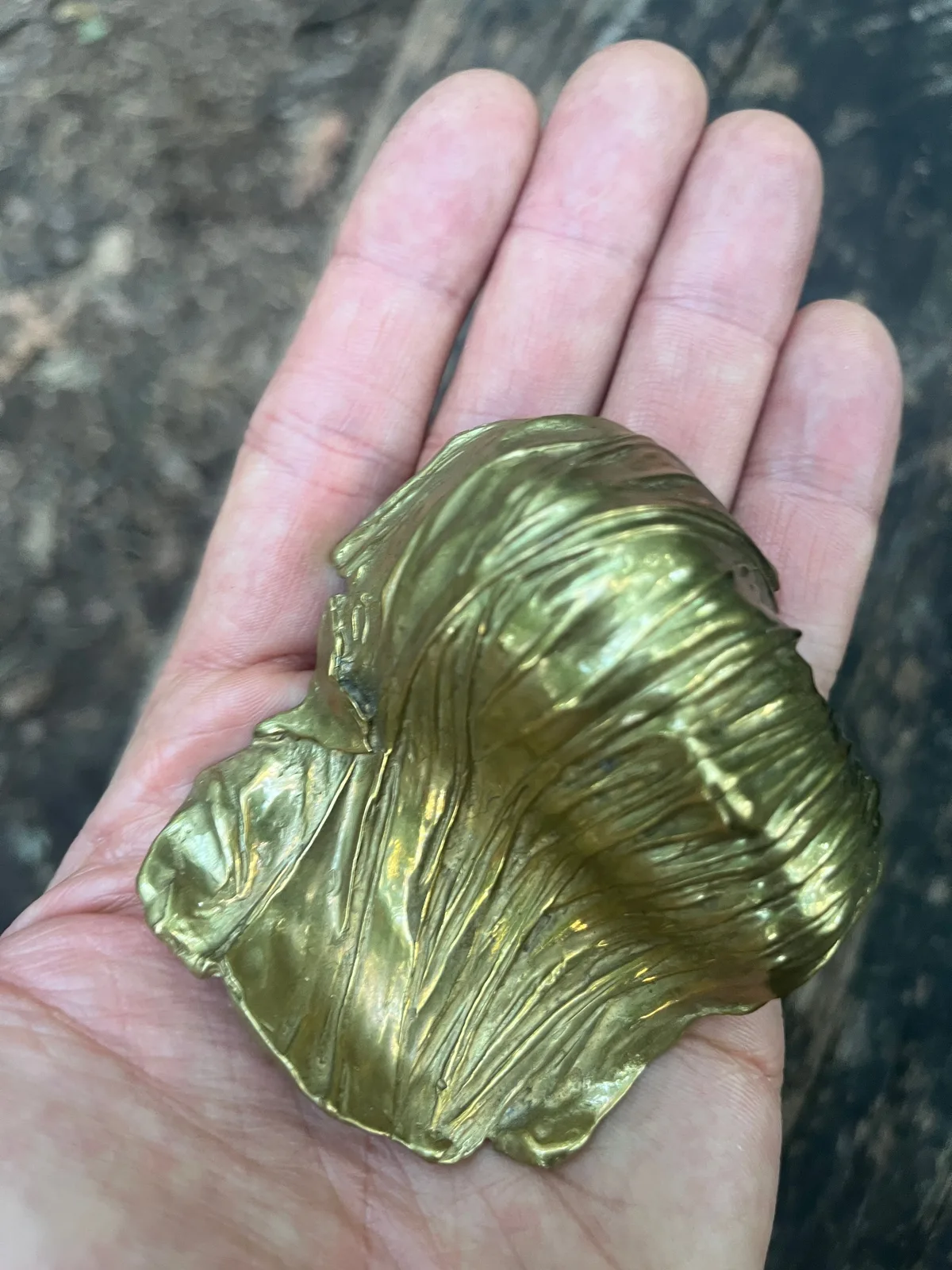 Visage Voilé — Mitoraj bronze, three-quarter view, gilded surface catching light